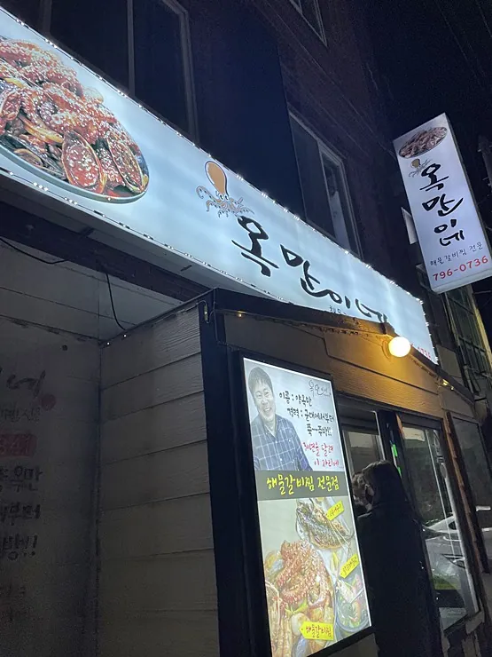 옥만이네 제주금능협재점 — 밤의 식당 간판과 입구 (2023-02-16 게시, 촬영일 미확인)